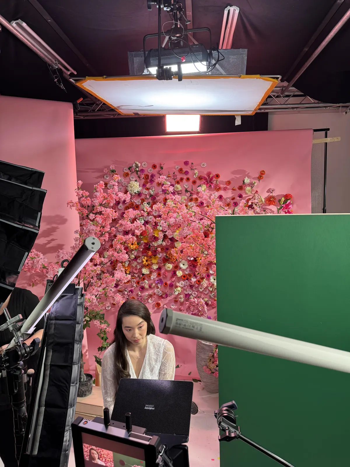 Set met bloemenwand en greenscreen, camera op de voorgrond