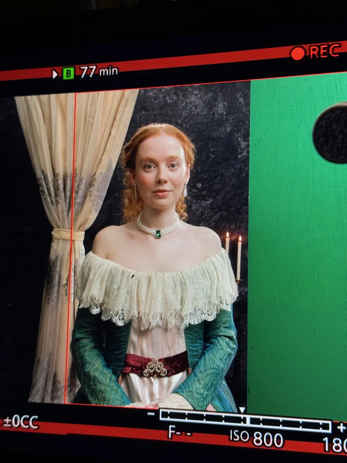Cameramonitor met een actrice in historisch kostuum voor een greenscreen