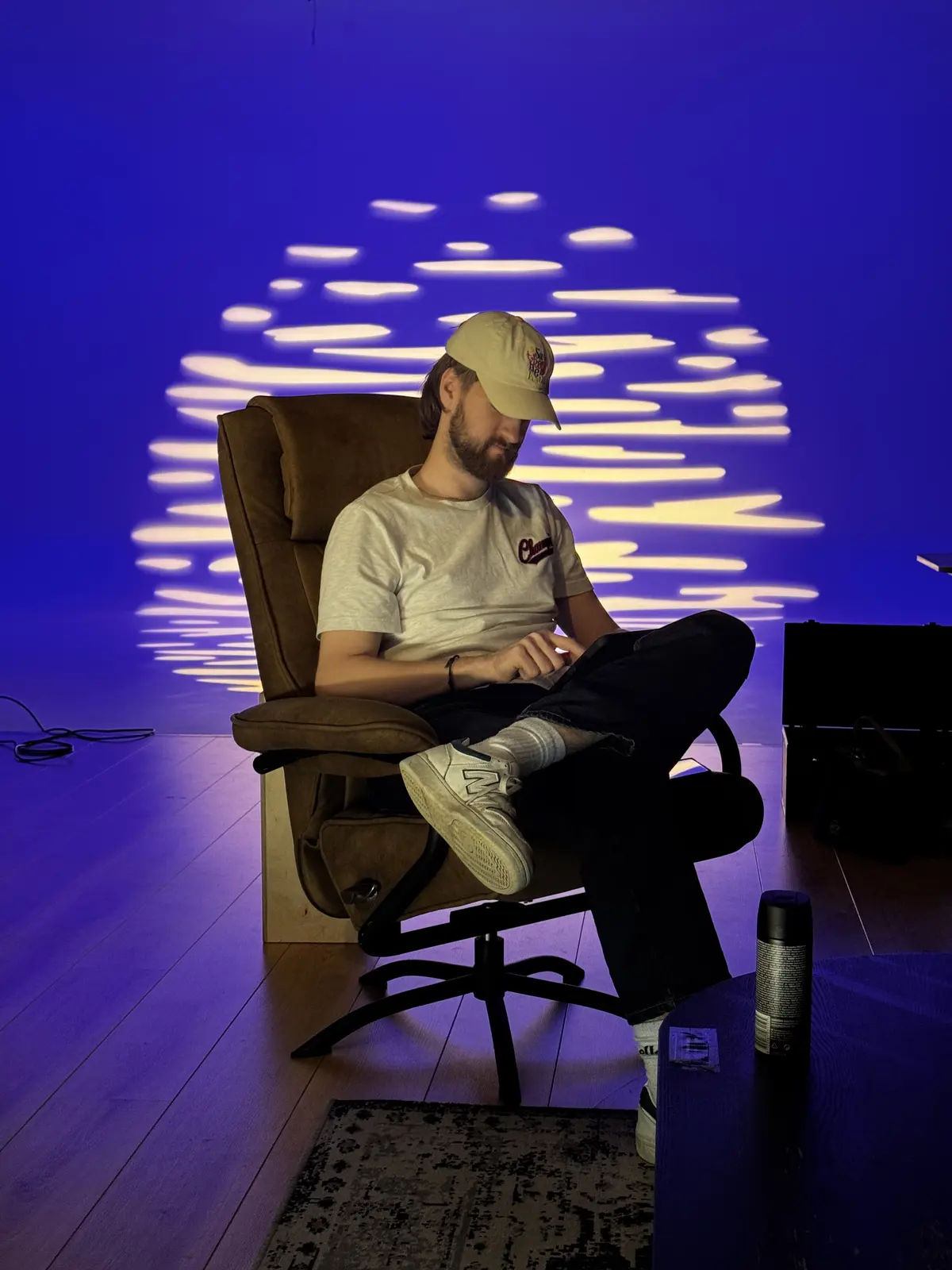 Man in een fauteuil voor een blauwe achtergrond met gobo-patroon