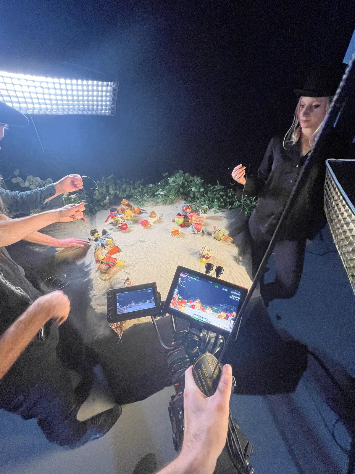 Productshoot op zand met fruit, crew kijkt mee op monitoren