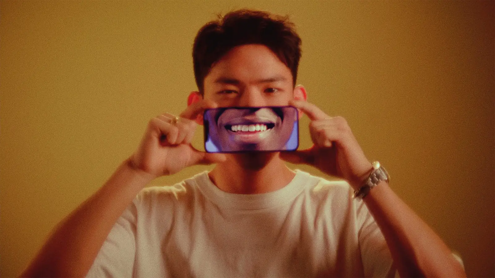 Still: jongen houdt een telefoon voor zijn mond